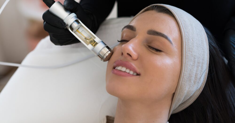 Aesthetician performing a HydraFacial treatment on a relaxed female