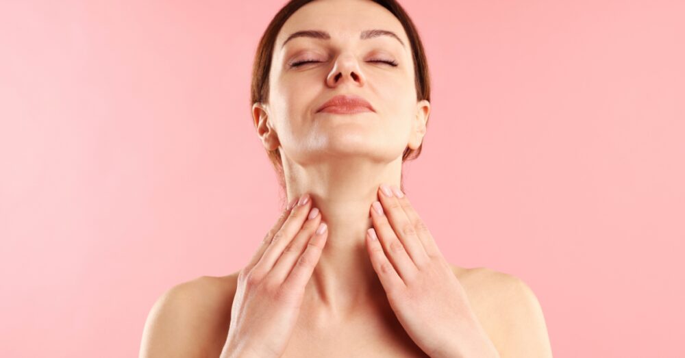 Woman with eyes closed gently touching her lifted, contoured neck