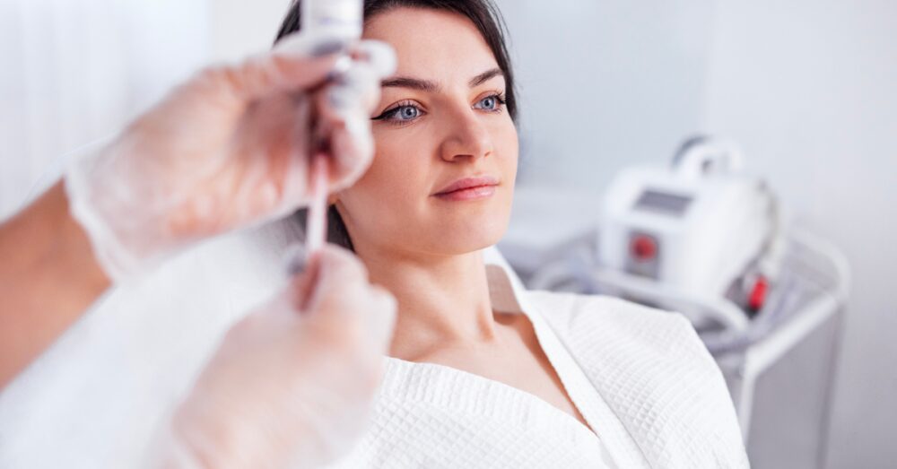 Practitioner administering Botox cosmetic injection to a female