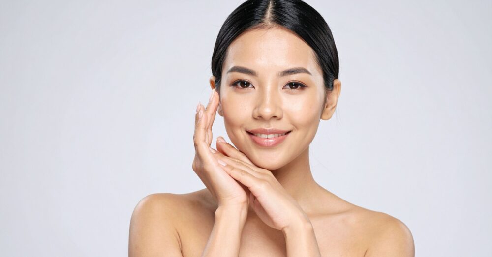 Woman smiling softly against a neutral background