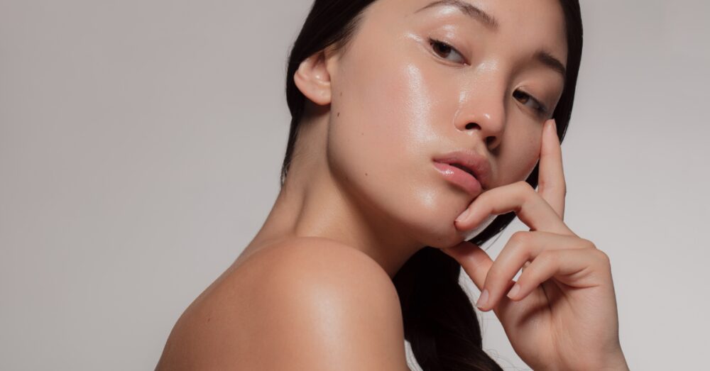 Woman with glowing skin looking over her shoulder